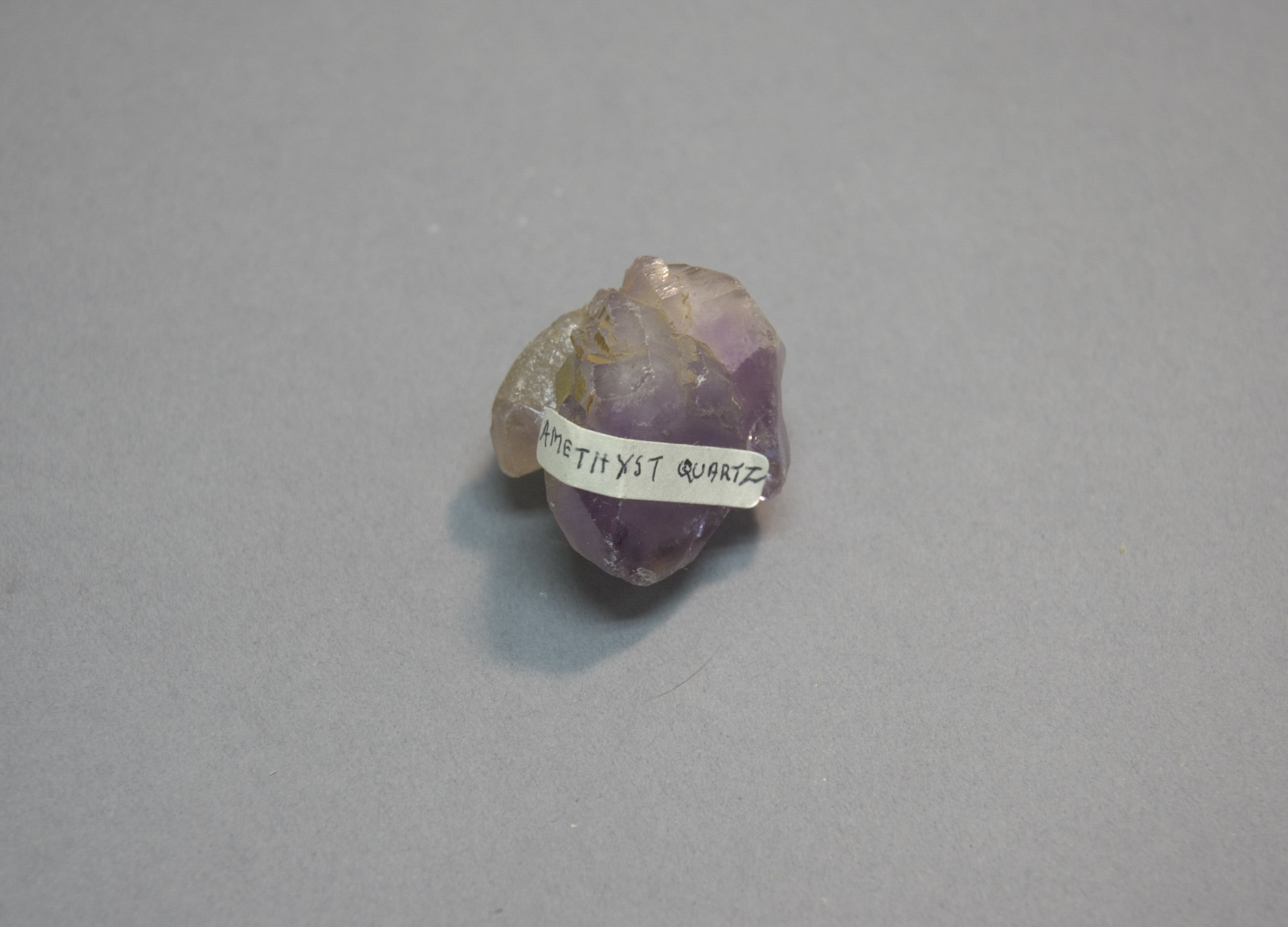 A museum sample of amethyst quartz with a handwritten label. Not the app.